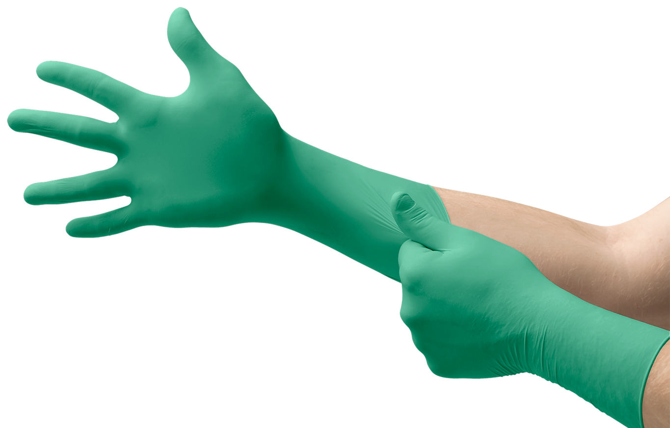 Eine Person zieht einen grünen, sterilen Nitril-Einmalhandschuh mit verlängerter Stulpe an. Die rechte Hand steckt bereits im Handschuh, während die linke den Stoff am Unterarm glattstreicht, damit er fest sitzt.