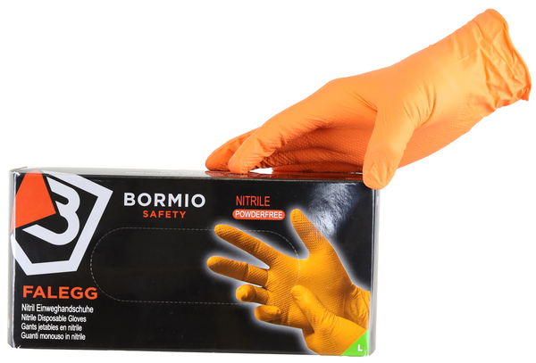 Eine Hand mit leuchtend orangefarbenem Nitril-Einweghandschuh ruht auf einer schwarzen Box mit der Aufschrift „Bormio Safety FALEGG Nitril Einweghandschuhe puderfrei“. Die Box zeigt auch ein oranges Handschuhmotiv.